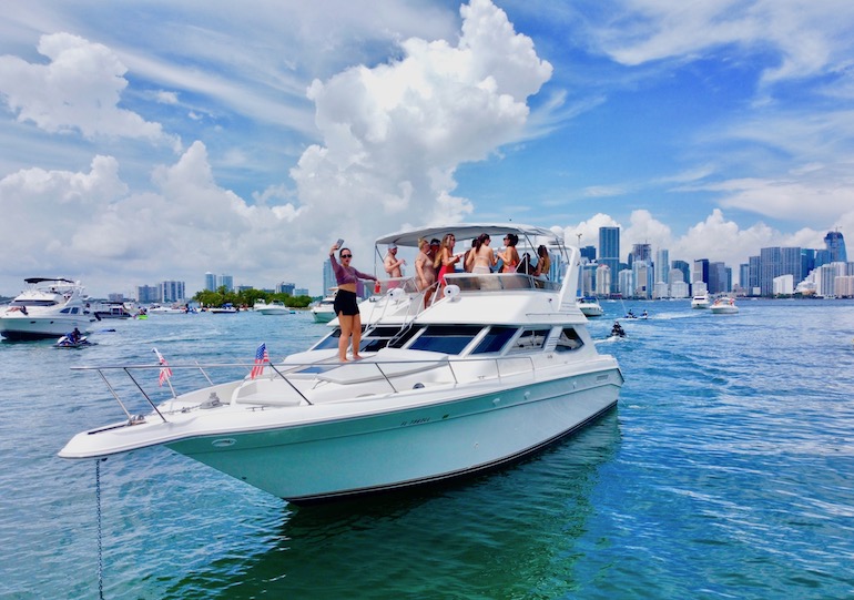 Aqua party boat group having fun in Miami on luxury charter yacht.