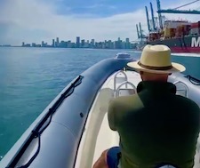 A man in panama hat enjoys a private boat tour of Miami's biscayne bay.