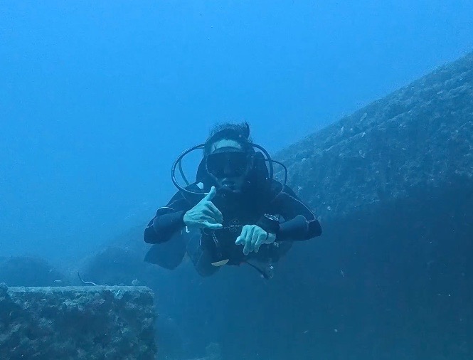 A scuba diver in Miami gives a thumbs up as he descends for a scuba diving experience.